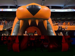 B.C. Lions' Mike Benson, from left, Ty Long and Adrian Clarke wait in an inflatable tunnel before running onto the field to play the Hamilton Tiger-Cats during a CFL football game in Vancouver, B.C., on Friday September 22, 2017. Out of the playoffs for the first time in 21 years, the B.C. Lions are trying make something out of two meaningless games to salvage a remarkably disappointing season. THE CANADIAN PRESS/Darryl Dyck