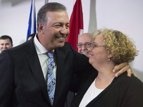 Quebec government MNA Sam Hamad hugs staff member Ihssane El Ghernati, right, as he leaves a news conference after he announced his resignation in St-Augustin-de-Desmaures, Que., on April 27, 2017. Voters in the Quebec City riding of Louis-Hebert will choose a new member of the legislature in a provincial byelection today. Ten candidates are in the running to fill the riding, left empty after the departure of longtime Liberal Sam Hamad in April, including former political attache Ihssane El Ghernati for the Liberals. THE CANADIAN PRESS/Jacques Boissinot