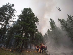 A helicopter drops water outside a fire guard line as B.C. Wildfire Service firefighters conduct a controlled burn to help prevent the Finlay Creek wildfire from spreading near Peachland, B.C., on Thursday, September 7, 2017. Climate change didn't directly cause major wildfires in Alberta and British Columbia this year but it did contribute to their extreme nature, says a University of Alberta researcher. THE CANADIAN PRESS/Darryl Dyck