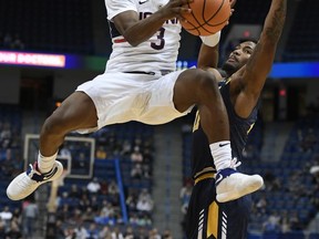 Connecticut's Alterique Gilbert soars to the basket as Merrimack's Tawayne Anderson, right, defends, during the first half of an NCAA college exhibition basketball game, Monday, Oct. 30, 2017, in Hartford, Conn. (AP Photo/Jessica Hill)