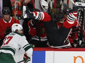 Chicago Blackhawks' Brent Seabrook, right, goes over the boards after missing a check on Minnesota Wild's Marcus Foligno during the first period of an NHL hockey game Thursday, Oct. 12, 2017, in Chicago. (AP Photo/Jim Young)