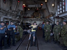 Master Seaman Kevin Dignard, centre, reacts while hugging his son Kaden, 7, as the HMCS St JohnÕs returned from deployment to Halifax on Thursday, October 5, 2017. The ship and its crew were returning from deployment on Operation RENAISSANCE in support of humanitarian efforts in the Caribbean after destruction caused by Hurricanes Irma and Maria. THE CANADIAN PRESS/Darren Calabrese