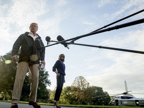 President Donald Trump, accompanied by first lady Melania Trump, listens to questions from reporters as he walks to board Marine One on the South Lawn of the White House in Washington, Tuesday, Oct. 3, 2017, for a short trip to Andrews Air Force Base, Md. and then on to Puerto Rico. (AP Photo/Andrew Harnik)