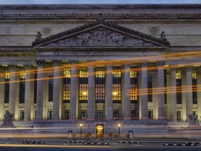 Traffic streaks past the U. S. National Archive headquarters building early in the morning, Tuesday, Oct. 24, 2017. President Donald Trump announced last week he intendeds to allow the National Archive to release additional classified documents on the assassination of President John F. Kenney. (AP Photos/J. David Ake)