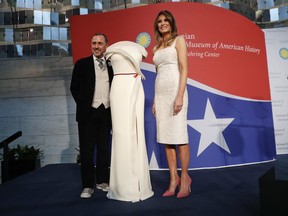First lady Melania Trump donates her inaugural gown, designed by Herve Pierre, left, to the First Ladies' Collection at the Smithsonian's National Museum of American History, during a ceremony in Washington, Friday, Oct. 20, 2017. (AP Photo/Pablo Martinez Monsivais)