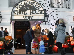 President Donald Trump and first lady Melania Trump hand out treats as they welcome children from the Washington area and children of military families to trick-or-treat celebrating Halloween at the South Lawn of the White House in Washington, Monday, Oct. 30, 2017. (AP Photo/Pablo Martinez Monsivais)