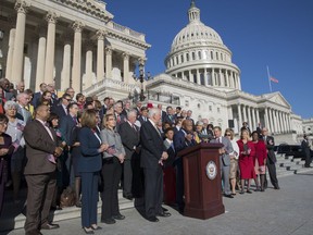 Civil rights leader Rep. John Lewis, D-Ga., speaking, and House Democrats, including former Rep. Gabby Giffords of Arizona, fourth from left, who survived an assassination attempt in 2011, call for action on gun safety legislation on the House steps Wednesday morning after the deadly mass shooting in Las Vegas this week, at the Capitol in Washington, Wednesday, Oct. 4, 2017. (AP Photo/J. Scott Applewhite)