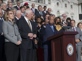Civil rights leader Rep. John Lewis, D-Ga., speaking, joined by, from left, former Rep. Gabby Giffords of Arizona, and Rep. Mike Thompson, D-Calif., call for action on gun safety legislation with fellow Democrats on the House steps Wednesday morning after the deadly mass shooting in Las Vegas this week, at the Capitol in Washington, Wednesday, Oct. 4, 2017. Giffords survived an assassination attempt in 2011 while speaking to constituents in Tucson. (AP Photo/J. Scott Applewhite)