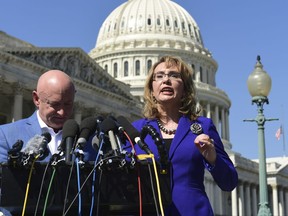 Former Rep. Gabrielle Giffords, D-Ariz., right, standing with her husband Mark Kelly, left, speaks on Capitol Hill in Washington, Monday, Oct. 2, 2017, about the mass shooting in Las Vegas. Giffords, was a congresswoman when she was shot in an assassination attempt in 2011. (AP Photo/Susan Walsh)