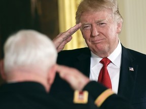 President Donald Trump, right, salutes retired Army Capt. Gary M. Rose, left, before bestowing him with the nation's highest military honor, the Medal of Honor, during a ceremony in the East Room of the White House in Washington, Monday, Oct. 23, 2017. (AP Photo/Susan Walsh)