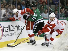 Detroit Red Wings defenseman Mike Green (25), Justin Abdelkader (8) and Dallas Stars right wing Brett Ritchie (25) compete for control of the puck in the first period of an NHL hockey game, Tuesday, Oct. 10, 2017, in Dallas. (AP Photo/Tony Gutierrez)