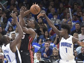 Orlando Magic forward Jonathan Isaac (1) blocks a shot by Miami Heat forward Bam Adebayo (13) as Magic center Bismack Biyombo (11) helps defend during the first half of an NBA basketball game Wednesday, Oct. 18, 2017, in Orlando, Fla. (AP Photo/Phelan M. Ebenhack)