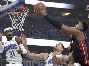 Miami Heat center Hassan Whiteside, right, puts up a shot over Orlando Magic guard Terrence Ross (31), center Nikola Vucevic, second from left, and guard Elfrid Payton during the first half of an NBA basketball game Wednesday, Oct. 18, 2017, in Orlando, Fla. (AP Photo/Phelan M. Ebenhack)