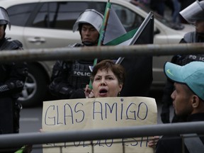 Supporters of Vice President Jorge Glas rally outside the Supreme Court in Quito, Ecuador, Monday, Oct. 2, 2017. Ecuador's Supreme Court has ordered Glas held in jail while he is investigated for allegedly taking bribes from a Brazilian construction giant involved in a sprawling regional graft scandal. The sign reads in Spanish "Glas friend." (AP Photo/Dolores Ochoa)