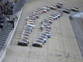 Martin Truex Jr., left, front, and Kyle Busch, right front, lead the field as they take the green flag for the start of the NASCAR Cup series auto race, Sunday, Oct. 1, 2017, at Dover International Speedway in Dover, Del. (AP Photo/Nick Wass)