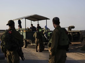 Israeli soldiers talk to field workers near the border with Gaza Monday, Oct. 30, 2017. The Israeli military said it discovered and detonated a militant tunnel on Monday that was dug from Gaza into Israel, in a rare flare-up along the tense border that has remained largely quiet since a 2014 war with Gaza's Hamas rulers. (AP Photo/Tsafrir Abayov)