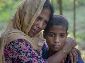Noor Mehar, a Rohingya Muslim woman, who crossed over from Myanmar into Bangladesh, along with her daughter Rasheeda, grieves for her three daughters after their boat capsized near Shah Porir Dwip, Bangladesh, Monday, Oct. 16, 2017. An overcrowded boat carrying Rohingya Muslims fleeing Myanmar capsized Monday in the Bay of Bengal near a Bangladeshi fishing village, killing 12 people, including six children, police said.(AP Photo/Dar Yasin)