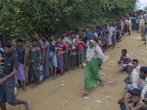 Rohingya Muslims, who crossed over from Myanmar into Bangladesh, wait for their turn to collect bamboos for the construction of shelters for them near Kutupalong, Bangladesh, Sunday, Oct. 22, 2017. More than 580,000 refugees have arrived in Bangladesh since Aug. 25, when Myanmar security forces began a scorched-earth campaign against Rohingya villages. Myanmar's government has said it was responding to attacks by Muslim insurgents, but the United Nations and others have said the response was disproportionate. (AP Photo/Dar Yasin)