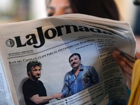 A woman reads La Jornada newspaper in Mexico City, on Jan. 10, 2016, which shows a picture of drug lord Joaquin Guzman, aka El Chapo, right, shaking hands with actor Sean Penn.