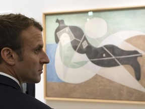 France's President Emmanuel Macron visits the "Picasso 1932: Erotic Year" exhibition at the Picasso museum in Paris, Sunday, Oct. 8, 2017. Macron said he likes in Picasso's paintings the "great sensuality" and at the same time, the "political meaning" especially in the years leading to the World War II. (Ian Langsdon/pool photo via AP)