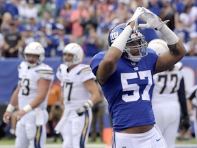 New York Giants linebacker Keenan Robinson (57) gestures after his team scored on a safety on a bad snap by the Los Angeles Chargers during the first half of an NFL football game, Sunday, Oct. 8, 2017, in East Rutherford, N.J. (AP Photo/Bill Kostroun)