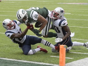 New York Jets tight end Austin Seferian-Jenkins (88) is tackled by New England Patriots' Malcolm Butler (21) and Duron Harmon (30) during the second half of an NFL football game, Sunday, Oct. 15, 2017, in East Rutherford, N.J. After further review the play was ruled a fumble into the end zone. (AP Photo/Bill Kostroun)