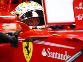 Ferrari driver Sebastian Vettel of Germany sitting in his car prepares for the third practice session at the Sepang International Circuit for the Malaysian Formula One Grand Prix in Sepang, Malaysia, Saturday, Sept. 30, 2017. (AP Photo/Eric To)