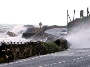 High winds and the sea batter the Antrim coast road, in County Antrim, Northern Ireland, Thursday, Dec. 5, 2013