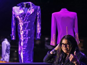 Musician Prince's sister Tyka Nelson poses for photographers in front of 'Purple Rain' costumes  at the 'My Name is Prince' exhibition at the O2 Arena in London, Thursday, Oct. 26, 2017. The exhibition showcases hundreds of never before seen artefacts direct from Paisley Park, Prince's famous Minnesota private estate. Visitors will get a unique insight into the life, creativity and vision of one of the most naturally gifted recording artists of all time from October 27, 2017 until January 7, 2018.(AP Photo/Frank Augstein)