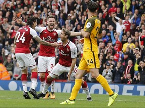 Arsenal's Nacho Monreal , center, celebrates with teammates after scoring during the English Premier League soccer match between Arsenal and Brighton and Hove Albion at the Emirates Stadium in London, Sunday, Oct. 1, 2017.(AP Photo/Frank Augstein)