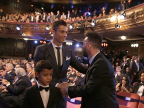 Portuguese soccer player Ronaldo, left, shakes hands wit Argentinian soccer player Lionel Messi during the The Best FIFA 2017 Awards at the Palladium Theatre in London, Monday, Oct. 23, 2017. (AP Photo/Alastair Grant)