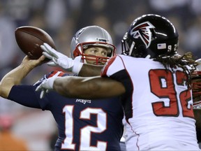 New England Patriots quarterback Tom Brady, left, passes under pressure from Atlanta Falcons defensive tackle Dontari Poe (92) during the first half of an NFL football game, Sunday, Oct. 22, 2017, in Foxborough, Mass. (AP Photo/Charles Krupa)