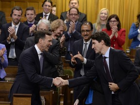 Finance Minister Bill Morneau shakes hands with Prime Minister Justin Trudeau after delivering his fall economic statement in the House of Commons in Ottawa, Tuesday, Oct.24, 2017.