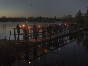 Fans of the Tragically Hip gather for a candlelight vigil by the water's edge in Bobcaygeon Ont. to pay tribute to singer Gord Downie who died on Tuesday night at the age of 53, Wednesday, October 18, 2017. THE CANADIAN PRESS/Fred Thornhill