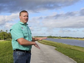 Almur Whiting of the Army Corps of Engineers talks to reporters Thursday, Oct. 19, 2017, in Clewiston, Fla. Whiting said there has been some seepage through the Herbert Hoover Dike but it is not significant. Federal officials are conducting daily inspections of the dike that surrounds Lake Okeechobee because of its near-record water levels but say it is not in danger of failing. (AP Photo/Alan Diaz)