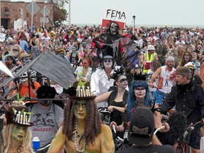 In this Sunday, Oct. 22, 2017, photo provided by the Florida Keys News Bureau, thousands of people participate in the Fantasy Fest Zombie Bike Ride in Key West, Fla. The ride was one of the many events set for the island city's 10-day Fantasy Fest costuming and masking celebration that continues through Sunday, Oct. 29. (Rob O'Neal/Florida Keys News Bureau via AP)