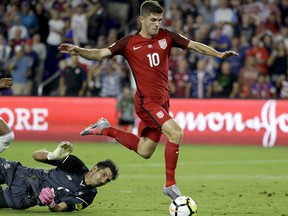United States' Christian Pulisic (10) gets past Panama goalkeeper Jaime Penedo (1) to score a goal during the first half of a World Cup qualifying soccer match, Friday, Oct. 6, 2017, in Orlando, Fla. (AP Photo/John Raoux)