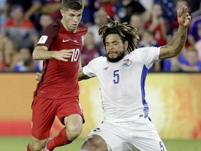 United States' Christian Pulisic (10) tries to get past Panama's Roman Torres (5) during the first half of a World Cup qualifying soccer match, Friday, Oct. 6, 2017, in Orlando, Fla. (AP Photo/John Raoux)