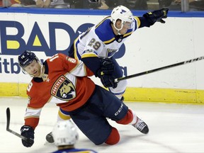 Florida Panthers' Mike Matheson (19) falls to the ice as St. Louis Blues' Vince Dunn (29) commits a holding penalty during the first period of an NHL hockey game, Thursday, Oct. 12, 2017, in Sunrise, Fla. (AP Photo/Lynne Sladky)