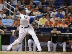 Miami Marlins' Giancarlo Stanton hits a RBI single to score Tyler Moore during the fifth inning of a baseball game against the Atlanta Braves, Sunday, Oct. 1, 2017, in Miami. (AP Photo/Lynne Sladky)