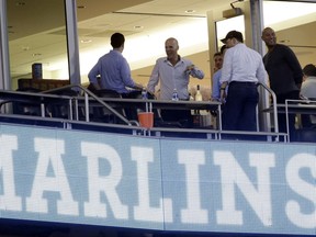 Derek Jeter, right, stands outside of a suite after a baseball game between the Miami Marlins and the Atlanta Braves, Sunday, Oct. 1, 2017, at Marlins Park in Miami. Major league owners unanimously approved the sale of the Marlins on Wednesday to an investment group led by Jeter and Bruce Sherman. (AP Photo/Lynne Sladky)