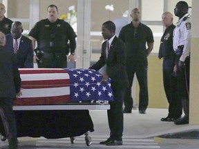 The casket of Sgt. La David T. Johnson of Miami Gardens, who was killed in an ambush in Niger. is wheeled out after a viewing at the Christ The Rock Church, Friday, Oct. 20, 2017  in Cooper City, Fla. (Pedro Portal/Miami Herald via AP)