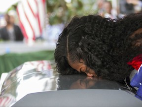 FILE - In this Saturday, Oct. 21, 2017, file photo, Myeshia Johnson kisses the casket of her husband, Sgt. La David Johnson during his burial service at Fred Hunter's Hollywood Memorial Gardens in Hollywood, Fla. Myeshia Johnson told ABC's "Good Morning America" on Monday, Oct. 23, 2017, that she has nothing to say to the president, adding that his phone call to her made "me cry even worse." (Matias J. Ocner/Miami Herald via AP, File)