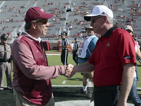 Florida State head coach Jimbo Fisher, left, shakes hands with Louisville head coach Bobby Petrino before the start of an NCAA college football game, Saturday, Oct. 21, 2017, in Tallahassee Fla. (AP Photo/Steve Cannon)