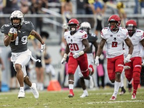 Central Florida's Mike Hughes (19) runs away from Austin Peay running back Prince Momodu (20) and defensive back Malik Boynton (2) and scores a touchdown on a kickoff return during the first half of an NCAA college football game, Saturday, Oct. 28, 2017, in Orlando, Fla. (AP Photo/Willie J. Allen Jr.)