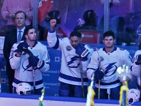 Tampa Bay Lightning right wing J.T. Brown, center, raises his fist in the air during the singing of the national nnthem before the start of an NHL hockey game between the Florida Panthers and the Tampa Bay Lightning, Saturday, Oct. 7, 2017, in Sunrise, Fla. (AP Photo/Wilfredo Lee),