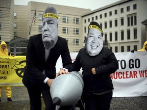 FILE - in this Sept. 13, 2017 file photo activists of the International Campaign to Abolish Nuclear Weapons (ICAN) protest against the conflict between North Korea and the USA with masks of the North Korean ruler Kim Jong Un, right, and the US president Donald Trump, left,  in front of the US embassy in Berlin, Germany. The International Campaign to Abolish Nuclear Weapons wins the Nobel Peace Prize. The Norwegian Nobel Committee honored the Geneva-based group "for its work to draw attention to the catastrophic humanitarian consequences of any use of nuclear weapons and for its ground-breaking efforts to achieve a treaty-based prohibition of such weapons." (Britta Pedersen/dpa via AP)
