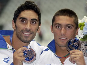 FILE - In this Sunday, Aug. 2, 2015, men's 4x100m freestyle relay team Italy's Filippo Magnini, left, and Michele Santucci hold up their bronze medals at the Swimming World Championships in Kazan, Russia. Two-time swimming world champion Filippo Magnini and sprint relay teammate Michele Santucci are being questioned by Italian anti-doping authorities over their relationship with a nutritionist being investigated for alleged illegal drugs distribution. (AP Photo/Michael Sohn, File)