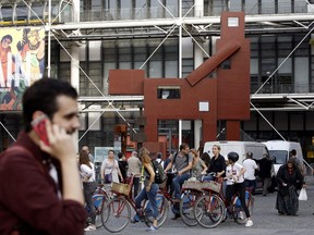 People view the sculpture "Domestikator" created by Dutch artist Joep van Lieshout and displayed in the plaza outside the Centre Pompidou modern art museum in Paris, Tuesday, Oct. 17, 2017.