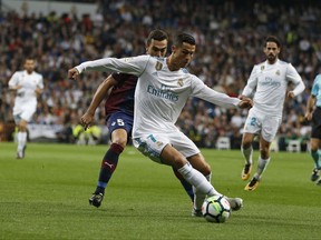 Real Madrid's Cristiano Ronaldo, front, vies for the ball with Eibar's Gonzalo Escalante during the Spanish La Liga soccer match between Real Madrid and Eibar at the Santiago Bernabeu stadium in Madrid, Sunday, Oct. 22, 2017. (AP Photo/Francisco Seco)